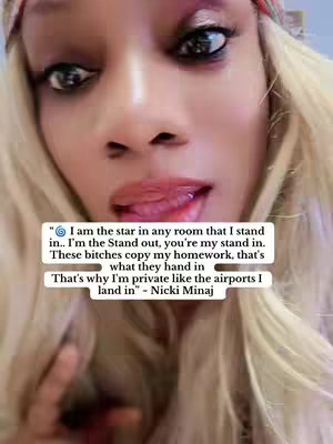 A close-up shot of a woman's face with blonde hair, red headband and visible text overlay in a white box. Her eyes are wide with heavy makeup, and her lips are parted slightly, revealing a glimpse of the tongue. The background is blurred out.
