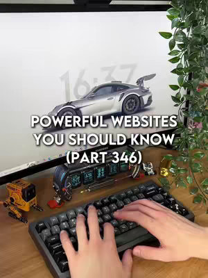 The image features a desk setup with a computer monitor displaying a silver sports car model in front of a light background. Text overlayed reads 'POWERFUL WEBSITES YOU SHOULD KNOW'. The desk is cluttered with mechanical keyboard and miniature decorative objects, with hands typing on the keyboard visible in the foreground, and plants on the right side. The composition is well-lit, and the camera angle offers a clear view of the setup.