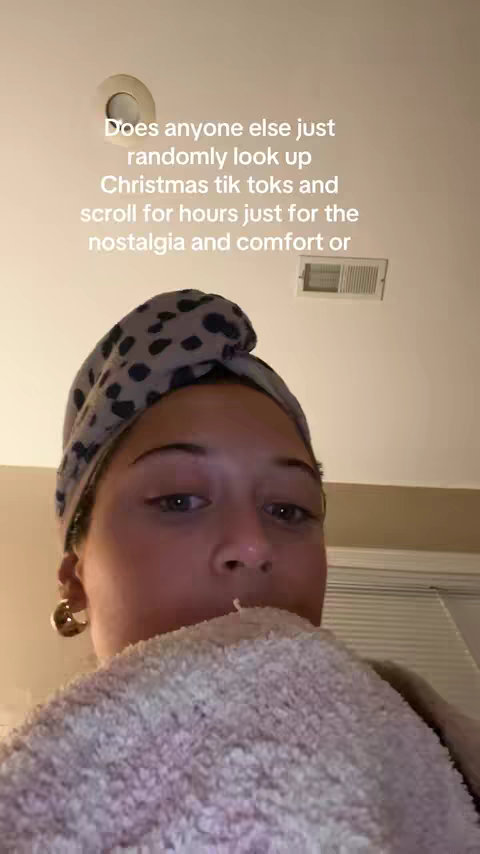 The cover image is a selfie-style shot taken indoors. The main visual element is a person, seen from the chest up, with a towel wrapped around their head and a fluffy white towel or cloth covering the lower part of their face. The person's face is partially obscured by the towel, but their eyes are visible. The background appears to be a neutral-colored ceiling and wall. The overall composition is simple and focuses on the subject's face and upper body.