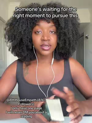 A woman with curly black hair is centered in the frame. She wears a black tank top and white earbuds. Text overlays at the top and bottom provide context, while the background suggests an indoor setting.