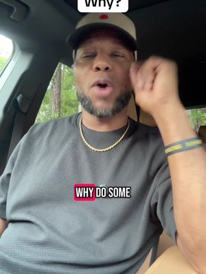 A man in a car wearing a baseball cap and a grey shirt is looking upwards and talking. Text overlays appear with a question mark and underneath there's text in a box that says "WHY DO SOME".