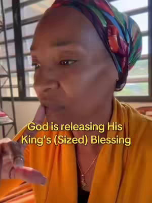 A woman with brown skin is shown from the chest up. She wears a patterned headscarf and a gold colored blouse. Gold text overlays on a gradient-yellow background. She has a slight smile and is touching her lips with her index finger.