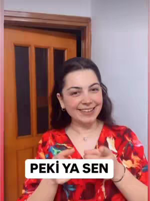 A woman in a red floral top is smiling and pointing towards the viewer. A white rectangle with the words 'PEKİ YA SEN' is imposed on the image.