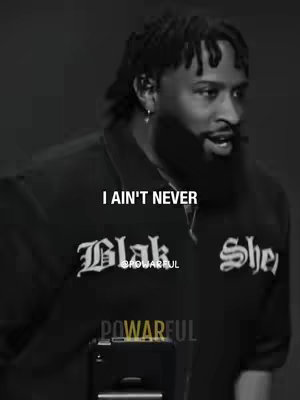 The cover image is a black and white, medium close-up shot of a Black man. The man has short, dark hair and a styled beard. He is wearing a black shirt with white lettering, and a silver earring. Text overlays are positioned at the head level of the man. The image has a high-contrast aesthetic.