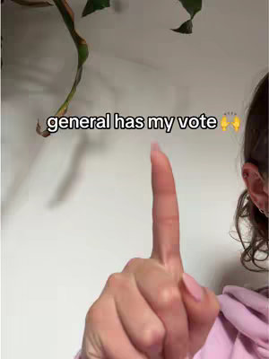 The cover image features a person's hand with a raised index finger, pointing upwards. The person's ear and part of their hair are visible on the right side, and a pink hoodie can be glimpsed. The background is a plain white wall, with a portion of a plant visible at the top left. Text overlayed on the image reads 'general has my vote'.