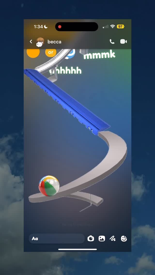 A phone screen displaying a game with a 3D track for a ball. The top portion of the screen shows the time and cellular data signal, along with a profile picture, the word 'or', and a few nonsensical words. The game appears to be a marble run with a multi-colored ball.