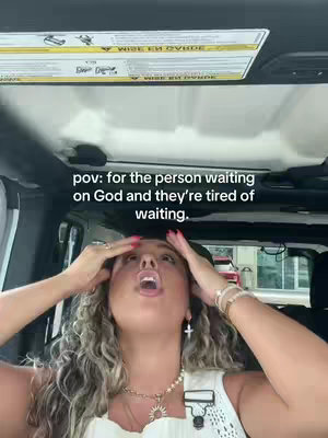 A woman inside a vehicle looks up with both hands on her head. The background shows the roof of the vehicle and a partially visible exterior scene. Text overlay at the top. She wears jewelry.