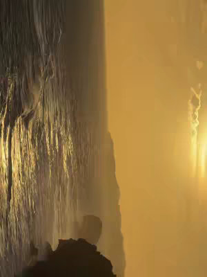An abstract image of water flowing over rocks. The left side has a large, textured section of what appears to be a rock face or waterfall edge, with a rough surface. The right side has a golden gradient.