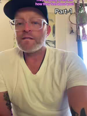 A medium shot features a man wearing a black cap, glasses, and a white V-neck shirt, centered in the frame. Visible text overlay suggests a relationship advice theme, 'Part-1'.