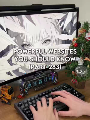 The image shows a person's hands over a keyboard with a computer monitor in the background. The monitor displays a black and white anime-style image of a person's eyes, partially obscured by abstract shapes. Text overlays on the screen say 'POWERFUL WEBSITES YOU SHOULD KNOW (PART 283)'. To the right is a small Christmas tree with ornaments. In the background, there's a desk with electronic devices.