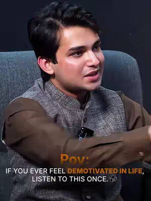 A medium shot features a young man seated and speaking, likely in an interview or vlog setting. He has dark hair and a slight smile, wearing a dark jacket over a brown shirt. The background is a neutral, possibly black, wall, which keeps the focus on the man. Text overlays state the content's theme.
