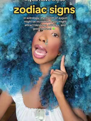 A selfie-style shot featuring a Black woman with vibrant blue, voluminous curly hair. She's wearing a white top and has a nose ring and what appears to be a small decorative item on her face. Her mouth is open, and she's pointing upwards with one finger, suggesting emphasis. Overlay text in a yellow and white design sits above her face.