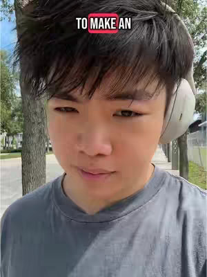 A medium shot of a young man wearing headphones and a gray t-shirt. The man is positioned on a sidewalk, trees and buildings are visible in the background. Text overlayed at the top says 'TO MAKE AN'.