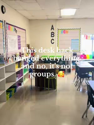 A classroom setting with desks, shelves, and whiteboards. The words "This desk hack changed everything and no, it's not groups" are added as a text overlay.