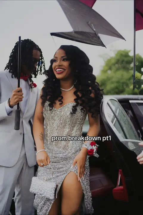 A woman in a sequined dress stands next to a man in a suit, under an umbrella. The woman smiles, holding a clutch. The background is slightly blurred and includes parts of a car. Text overlay says, "prom breakdown pt1."
