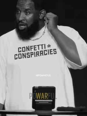 A black and white image of a man looking surprised, with his hand near his ear as if adjusting an ear piece. He is wearing a t-shirt that says "CONFETTI*
CONSPIRACIES". In the lower portion of the image there is tech such as a microphone.