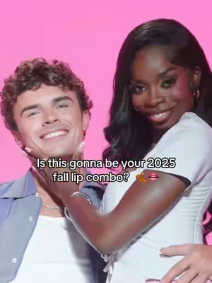 A cover image of two people, a man and a woman, posing closely together, seemingly promoting a makeup product. The man has short curly hair and a light complexion. The woman has long, dark hair and a darker complexion. They are both smiling, with the woman's arm around the man. The background is solid pink. Text overlay appears at the bottom conveying a question centered around lip combinations.