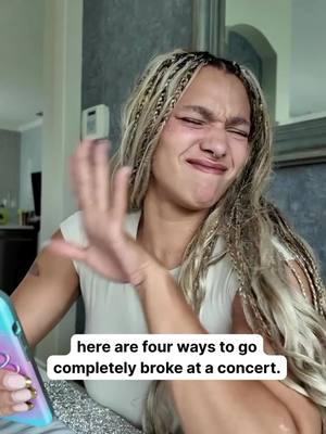 A woman with blonde braids makes a disgusted face and holds a phone with a protective case in her left hand, as her right hand waves outwards animatedly. White text overlaid across the image reads "here are four ways to go completely broke at a concert."