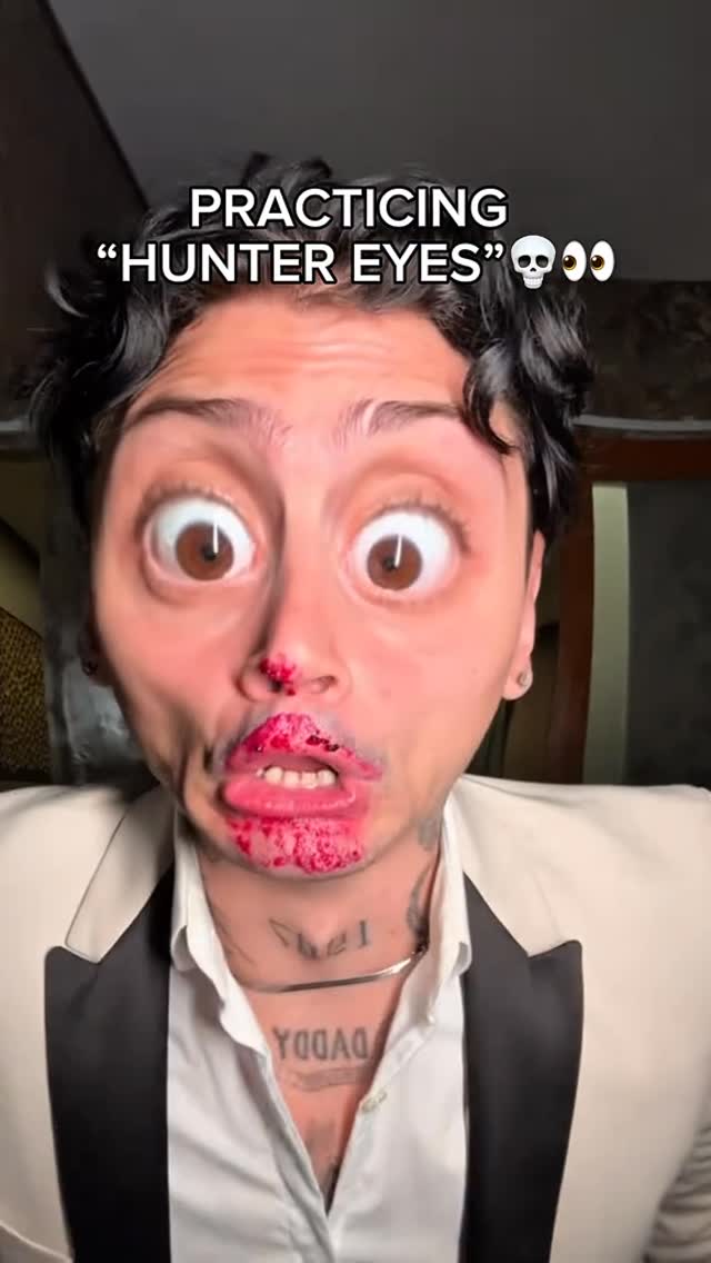 A close-up shot features a young man's face, distorted with a humorous filter. His eyes and lips are unnaturally large, emphasizing the dramatic effect of the filter. The text overlay reads, PRACTICING "HUNTER EYES".