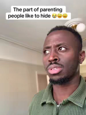 The image shows a black man with a concerned expression, looking off to the side. Above his head, text says, "The part of parenting people like to hide" with three emoticons, one with tears of joy, and two with sad faces. The man is wearing a green collared shirt, and the background is softly blurred with visible ceiling and wall details.