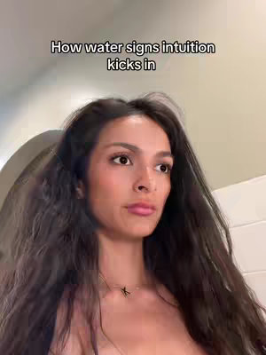 A woman with long dark hair looks slightly concerned, with text overlayed at the top. The background is an enclosed space with a light-colored wall and a white door.