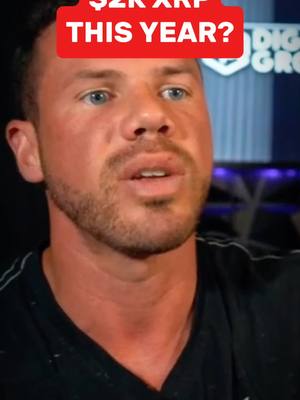 A man with short brown hair, a beard, and blue eyes is centered in the frame, with a red rectangular text overlay above his head. The text overlay displays the text '$2K XRP THIS YEAR?' in bold white letters. He's wearing a black shirt.