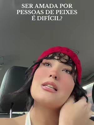 A woman with black hair and a red knitted headband looks up in the car. Text overlay at the top of the image. The background is soft focus and out of view.