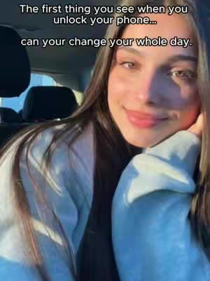 A woman with long brown hair is seen, smiling into the camera; the background reveals the inside of a car. Text overlays the top portion of the image.