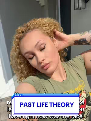 A selfie-style shot with a woman posing, with her hair styled in curly blonde locks. She is wearing a green top. The text overlay reads 'PAST LIFE THEORY' in a blue and white rectangular box. The background is neutral with a hint of a building.