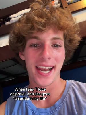 A young man with curly brown hair smiles, his face taking up most of the frame. The background is slightly out of focus but appears to be a bedroom setting, with a bunk bed visible. Text overlays are present at the bottom of the image.