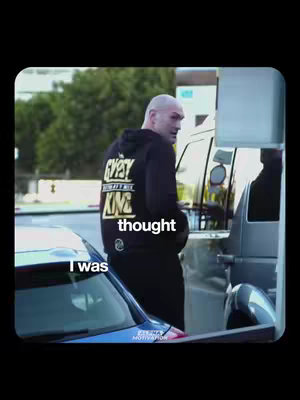 The cover image appears to be a photo taken outdoors, likely a candid shot. The subject, Tyson Fury, is seen from the back and side, wearing a black hoodie with gold lettering. He's positioned near a car, near a gas station or similar outdoor location with a sign visible in the background. The overall scene has a casual, non-staged feel.
