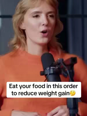 The cover image features a woman speaking into a microphone, with a text overlay below. She has blonde hair and is wearing an orange top. The background is blurred.