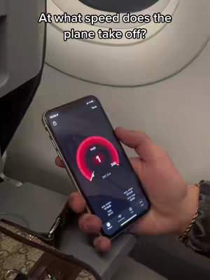 The image shows a person holding a phone inside an airplane. The phone displays an app interface showing speed, and the text overlay reads "At what speed does the plane take off?"