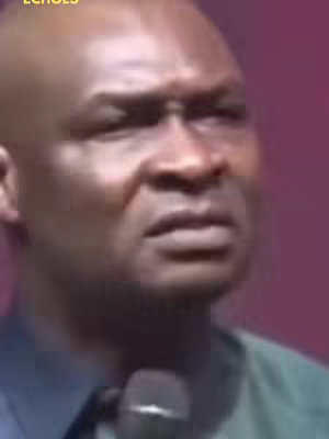 The cover image is a medium shot of a bald man, Apostle Joshua Selman, with a concerned expression. He is looking slightly off-center with a subtle frown and his lips pursed. The background is a solid dark pink or purple, which gives a stark contrast to his face. He’s wearing a dark, likely green, collared shirt. A microphone is present and is visibly below his mouth, indicating a public speaking environment.