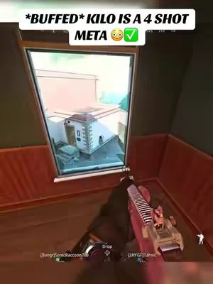 The cover image is a first-person view from a video game, presumably Warzone. The player is holding a gun, the Kilo, inside a building. The scene visible through a window shows other buildings and blue skies. The upper-left corner contains text: "*BUFFED* KILO IS A 4 SHOT META 😳✅". The color palette is dominated by greens, browns, and reds, typical of a first-person shooter. The layout is composed of the in-game view filling most of the frame, with the overlay at the top.