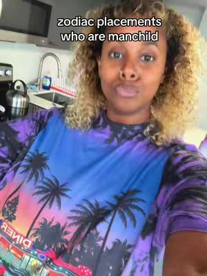 A woman with curly blonde-tipped hair is the focus of the image, framed from the chest up. She wears a tie-dye shirt with a palm tree design. The background, partially visible, shows a kitchen setting with a microwave and sink. Text is overlaid at the top of the image.