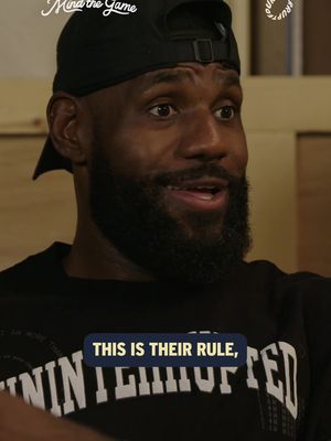 A close-up shot features LeBron James wearing a black cap and a dark t-shirt. A text overlay in a blue box appears to be a quote from him. The background is a blurred interior with wooden panels, suggesting a video interview.