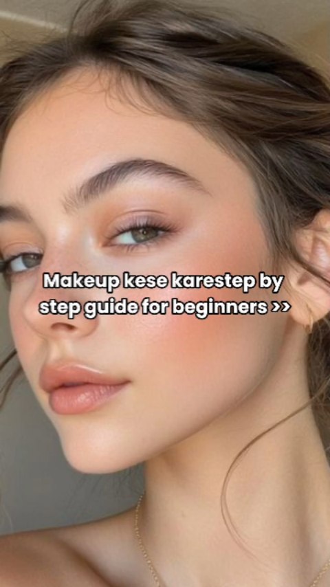 A close-up shot of a woman's face highlighting her makeup. The woman has brown hair and is looking slightly to the side. The background is blurred, focusing attention on the makeup tutorial concept and face.