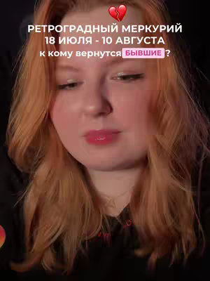 A selfie-style video featuring a fair-skinned woman with long, wavy reddish-orange hair. She has full lips and is looking at the camera. Text overlays are present above the subject's head, including a heart symbol, and in the frame with text about Retrograde Mercury.