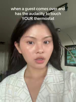A young woman looks at the camera with a slight look of surprise, wearing a white collared shirt with a geometric pattern. Text over the image reads "when a guest comes over and has the audacity to touch YOUR thermostat."