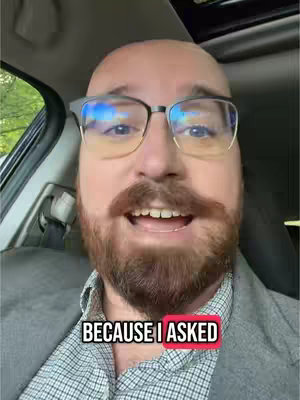 A bald man with a beard and glasses is in the driver's seat of a car. Text overlay reads "BECAUSE I ASKED".