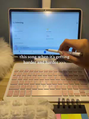 A tablet showing an app screen is the central focus, with a pink keyboard below, and a hand holding a pen and stylus pointing at the screen with the text overlayed is 'this song when it's getting harder and harder >>>'.