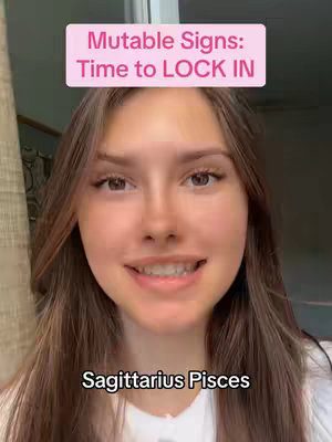 A young woman with long brown hair, wearing a white top, smiles directly at the camera. Above her head is a pink rectangle with white text. At the bottom of the image, dark text is visible, likely representing astrological signs. The background is softly blurred with hints of outdoor lighting.