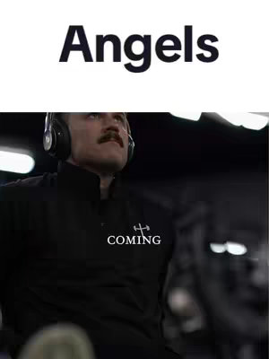 The cover image shows a man wearing headphones and a black jacket in a gym setting. Above him, in large, bold text, is the word "Angels." Below the text, the word "COMING" is displayed on his jacket. The background is blurred, suggesting an indoor environment.