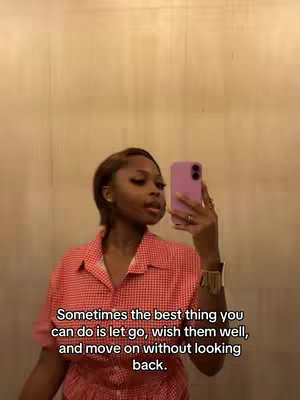 A selfie shot taken with a phone shows a woman with brown hair in a red and white gingham top holding the phone up to take the photo. The background is a plain beige color, and the text overlayed on the bottom indicates this video is about letting go.