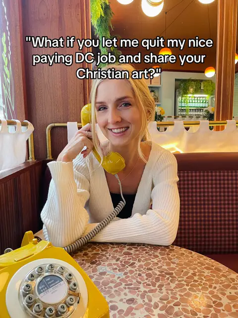 A woman sits at a table holding a yellow rotary phone receiver to her ear, smiling at the camera. The background is a restaurant booth. Text overlayed on the image reads, "What if you let me quit my nice paying DC job and share your Christian art?"