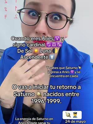A woman with dark hair and glasses is looking at the camera with a moderate expression, overlayed with text about Saturn in Aries and astrology information.