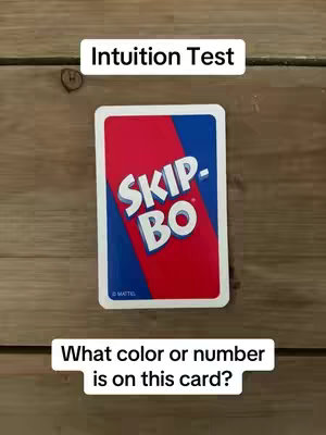 A vertical shot shows a wooden surface with a game card and text overlays. The central focus is a Skip-Bo card displayed face down, with its back visible. Above the card, a white rectangular box contains the text 'Intuition Test' in a concise sans-serif font. Below the card, another white rectangle says, 'What color or number is on this card?' Wooden planks form the background, providing a natural texture and warm tones.