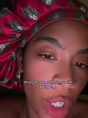 Close-up shot of a person with a red patterned headscarf. The person's face fills most of the frame, with the text overlayed at the bottom. The background is dark, and the lighting appears soft.
