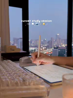 The cover image shows a person writing on a tablet with a stylus. The tablet is on a desk with a keyboard in front of a large window. In the background, a city skyline is visible at sunset.